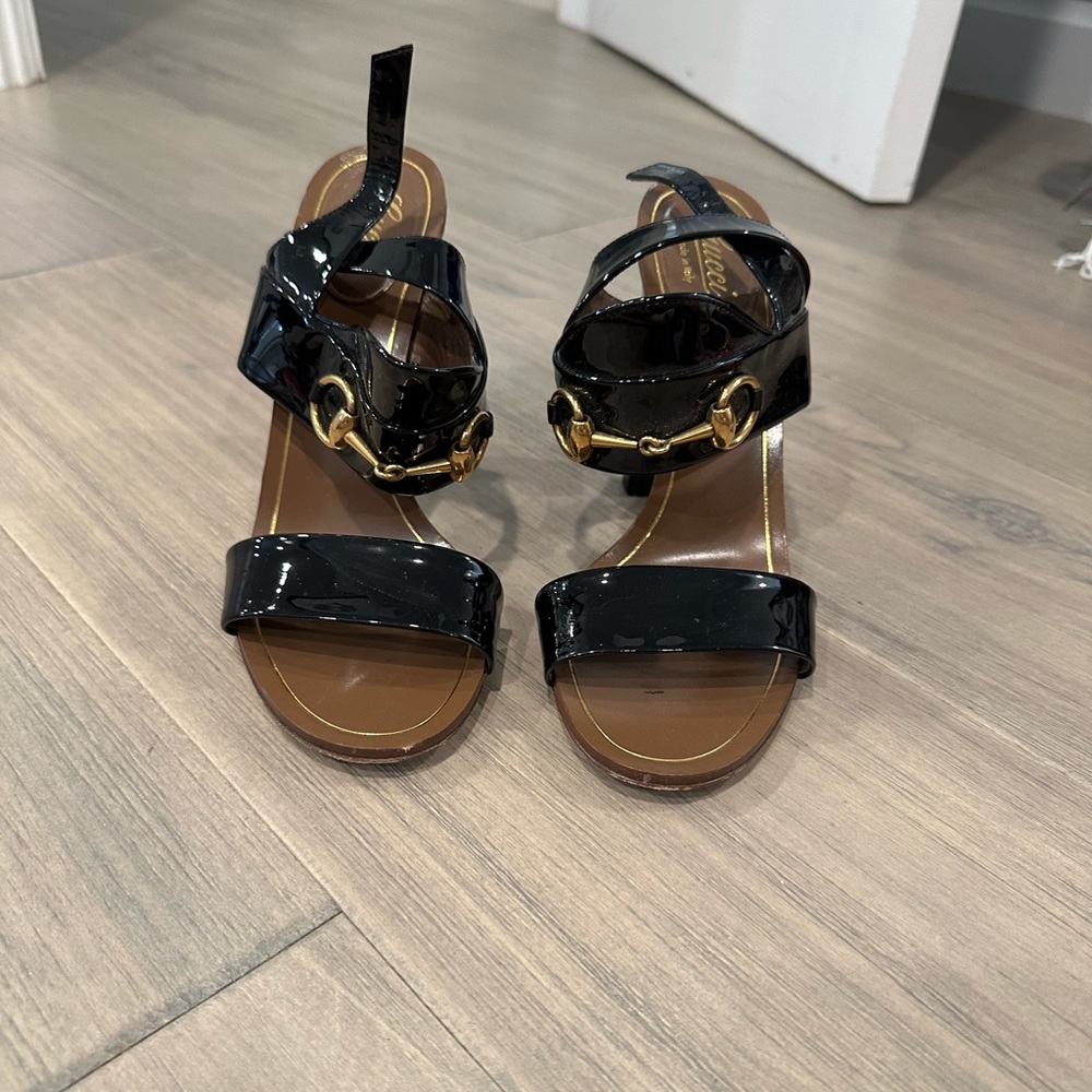 Stunning authentic pair of patent leather horsebit sandals with gold hardware